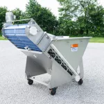 Incline conveyor for vacuum metering system